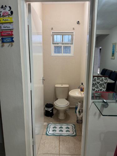 a small bathroom with a toilet and a sink at Casa Ramos in Itanhaém