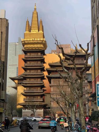 a tall building with a large tower in a city at Tech-X Jing'an Hotel in Shanghai