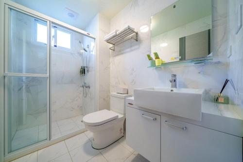 Un baño con inodoro, lavabo y ducha. en Senhuojia Homestay, en Toucheng