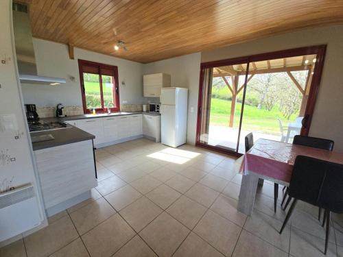 une grande cuisine avec une table et une salle à manger dans l'établissement Maison cosy près de Domme avec jardin, terrasse et cheminée, à proximité des attractions touristiques - FR-1-616-43, à Domme