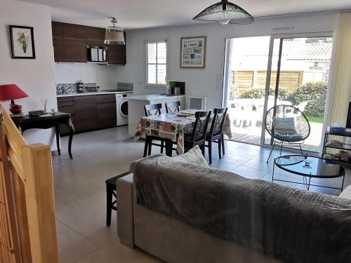 un salon avec un canapé et une table dans l'établissement Maison sous les pins pour 4/5 personnes, plage proche, parking privatif - FR-1-357-262, à La Tranche-sur-Mer