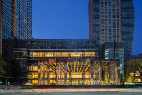 a building with a lit up facade with tall buildings at YTL OuYue International Hotel in Wenzhou