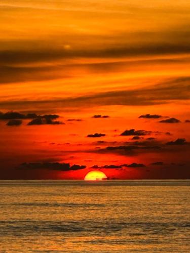 a sunset over the ocean with the sun at Dolphin Bay Island Resort 海豚岛 in Kota Belud
