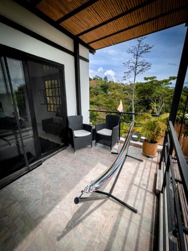 a balcony with a view of a house at Finca Boutique Los Laureles Villeta in Villeta