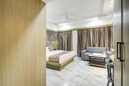 a hotel room with a bed and a couch at Hotel Royal Stay, Pakwan Sg Highway in Ahmedabad