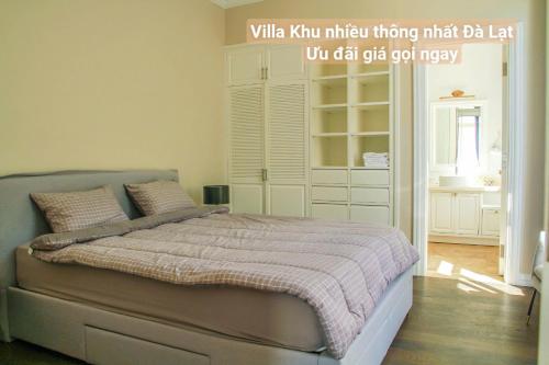 a bedroom with a bed with a whitekulum mirror hiding dablll at Chillin Villa - Biệt Thự Đà Lạt Khu Nhiều Thông Gần Hồ Tuyền Lâm in Xuan An