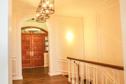 a hallway with a staircase and a chandelier at Chillin Villa - Biệt Thự Đà Lạt Khu Nhiều Thông Gần Hồ Tuyền Lâm in Xuan An