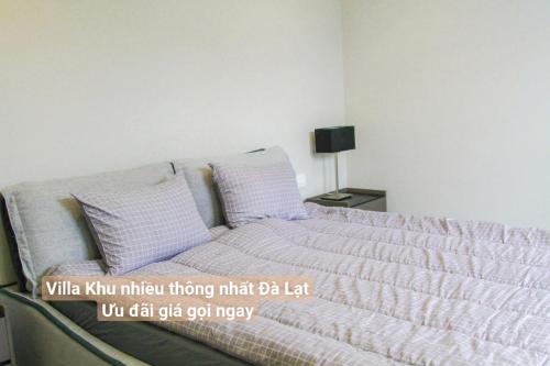 a bed with white sheets and pillows in a bedroom at Chillin Villa - Biệt Thự Đà Lạt Khu Nhiều Thông Gần Hồ Tuyền Lâm in Xuan An