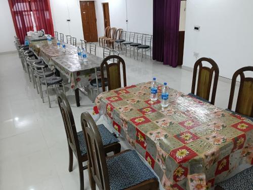 a room with long tables and chairs with tables at Monal Inn in Mīlam