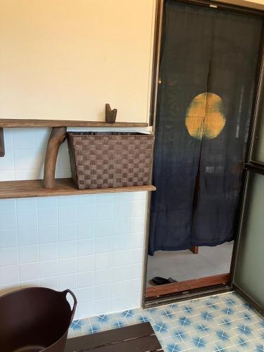 a bathroom with a shower with a window with an umbrella at 海が目の前の秘境にある癒しの宿めぐりて in Setouchi
