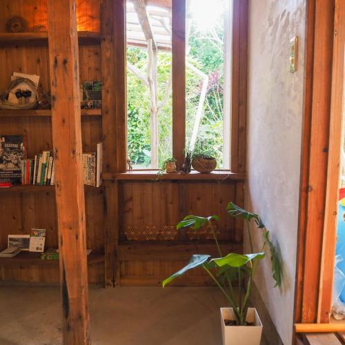 a room with a window and a potted plant at 海が目の前の秘境にある癒しの宿めぐりて in Setouchi