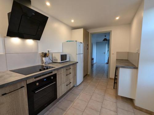 une cuisine avec un évier et un réfrigérateur dans l'établissement Gîte typique Sud Charente, 2 chambres, terrasse, animaux acceptés, proche circuits randonnées - FR-1-653-78, à Salles-Lavalette