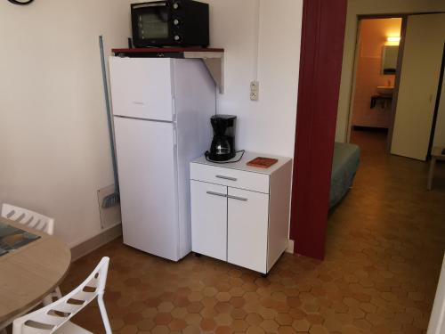 Elle comprend un réfrigérateur blanc et une cafetière. dans l'établissement Appartement cosy en demi-sous-sol à 300m de la plage - Idéal pour 2/3 personnes - FR-1-357-317, à La Tranche-sur-Mer