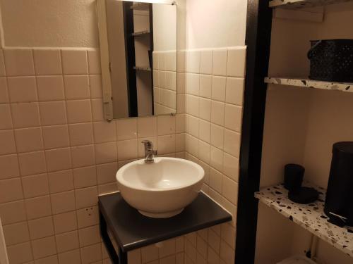 un lavabo blanc dans une salle de bain avec un miroir dans l'établissement Appartement cosy en demi-sous-sol à 300m de la plage - Idéal pour 2/3 personnes - FR-1-357-317, à La Tranche-sur-Mer