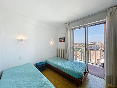 Cette chambre comprend deux lits et une grande fenêtre. dans l'établissement Bel Appartement F2 en 1ère Ligne avec Ascenseur - 4 Pers - Palavas-les-Flots - FR-1-715-88, à Palavas-les-Flots