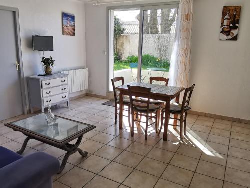 un salon avec une table et des chaises de salle à manger dans l'établissement Appartement cosy pour 2, centre-ville, proche plage, parking privé - FR-1-357-334, à La Tranche-sur-Mer