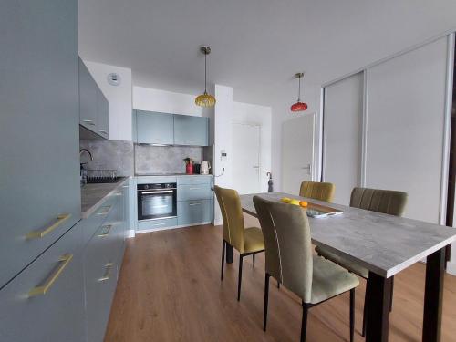 - une cuisine avec une table à manger et des chaises dans l'établissement Appartement à 2 pas de la plage avec parking à Royan - FR-1-550-90, à Royan