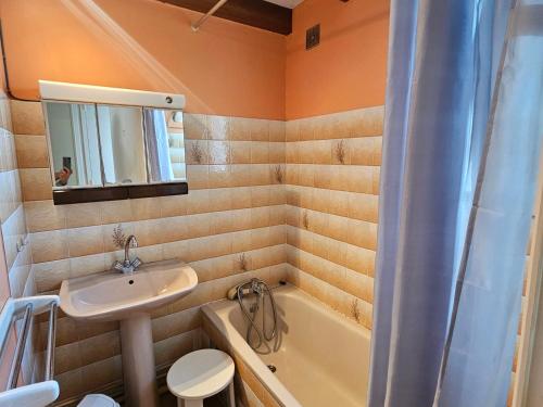 une salle de bain avec un lavabo et une baignoire dans l'établissement Appartement 4 pers à Royan avec balcon et parking proche plage du Chay - FR-1-550-89, à Royan