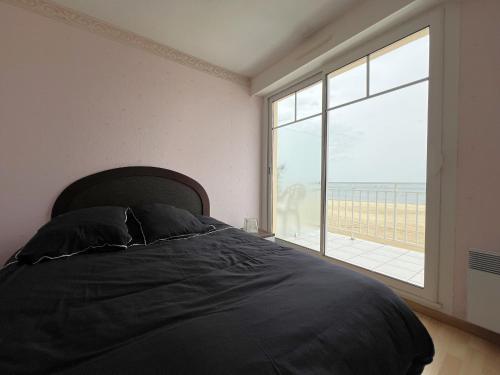 une chambre avec un lit et une grande fenêtre dans l'établissement Appartement avec vue bassin, accès plage, parking inclus - FR-1-474-278, à Arcachon
