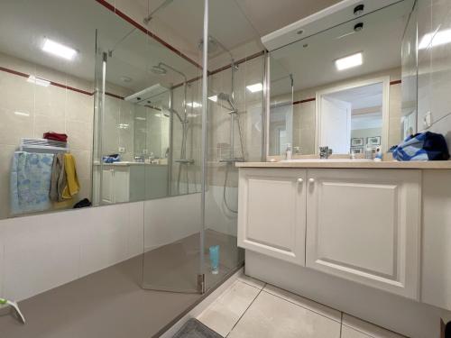 une salle de bain blanche avec une douche et un lavabo dans l'établissement Appartement avec vue bassin, accès plage, parking inclus - FR-1-474-278, à Arcachon