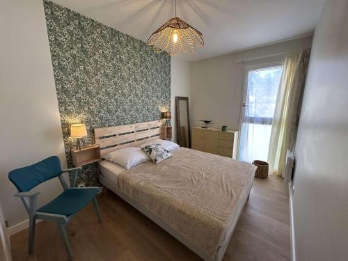 - une chambre avec un lit, une chaise et un lustre dans l'établissement Appartement 2P + Alcôve, 200m de la plage, Parking - FR-1-224C-344, à Saint-Jean-de-Monts