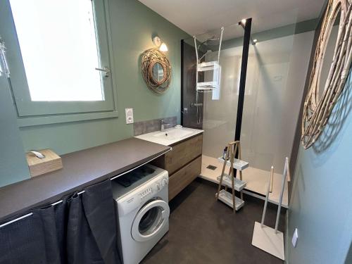 une buanderie avec une machine à laver et un lave-linge dans l'établissement Appartement 2P + Alcôve, 200m de la plage, Parking - FR-1-224C-344, à Saint-Jean-de-Monts