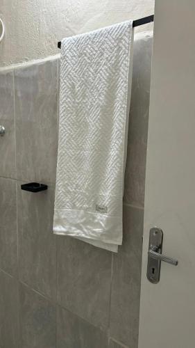 - une serviette blanche suspendue à une porte de douche dans l'établissement casa 2 próximo centro, à São Roque