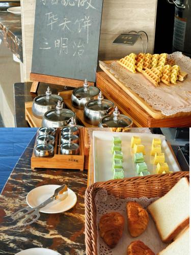 a buffet of food with bread and pastries on a table at Guangzhou Wenyue Lihua Hotel in Huadu