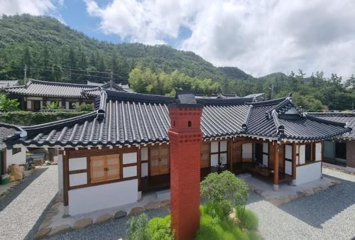 a house with an asian roof with a red pole at Museon Hanok Stay Jebi in Haenam