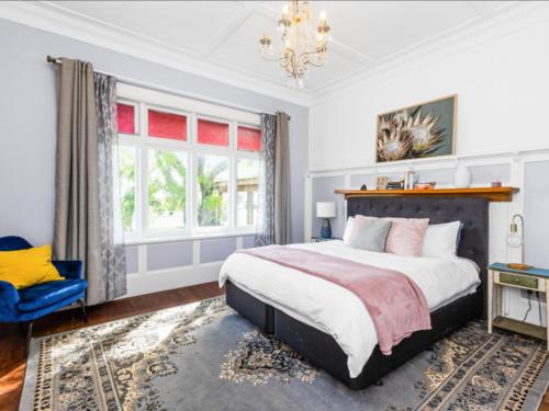a bedroom with a large bed and a chandelier at Beautiful villa in Napier with spa in Napier