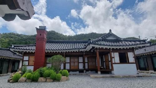 an asian style building with a brick chimney at Museon Hanok Stay Jebi in Haenam
