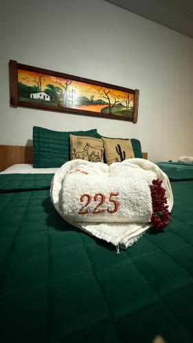a bed with a blanket with the number on it at Apt Flat 225 Condomínio Pedra do Rodeadouro in Bonito