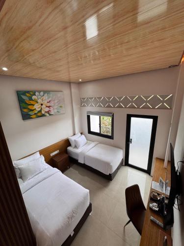 a hotel room with two beds and a desk at ABE Hotel & Convention in Siborongborong