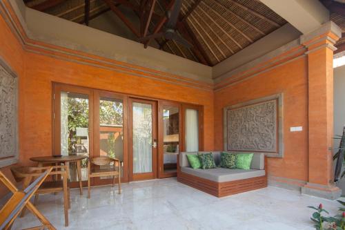an outdoor living room with a couch and a table at Legian Beach Hotel in Legian