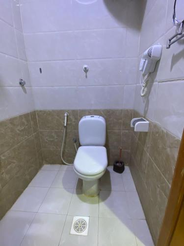 a bathroom with a toilet and a phone on the wall at شاليه ضيعتنا الريفية الفندقية in Jeddah