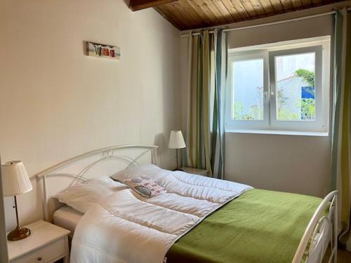 une chambre avec un lit blanc avec une fenêtre dans l'établissement Maison de plain pied à L'Herbaudière près plage et ports - 4 pers. - FR-1-823-122, à Noirmoutier-en-l'lle