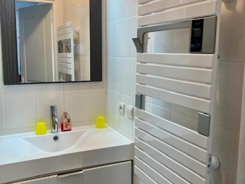une salle de bain blanche avec un lavabo et un miroir dans l'établissement Maison de plain pied à L'Herbaudière près plage et ports - 4 pers. - FR-1-823-122, à Noirmoutier-en-l'lle