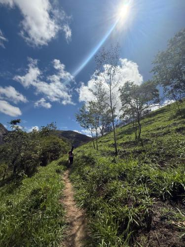 a person walking down a dirt path on a hill at Apt Flat 225 Condomínio Pedra do Rodeadouro in Bonito