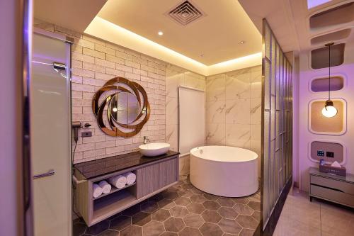a bathroom with a tub and a sink and a mirror at Motel Well in Zhubei