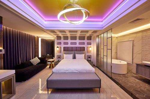 a bedroom with a bed and a couch and a tub at Motel Well in Zhubei