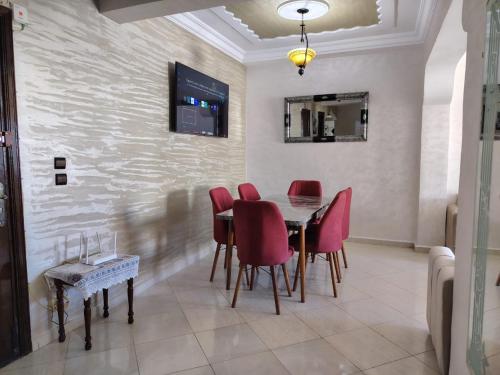 a dining room with a table and red chairs at casa bella in Casablanca