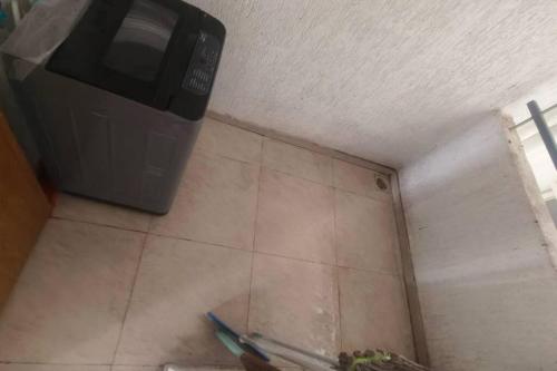 Un microondas en la esquina de una habitación. en Elements Hinjewadi ph1 2bhk, en Pune