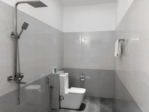 a white bathroom with a toilet and a shower at Lum Residence in Ahangama