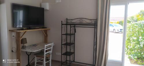 - un salon avec une télévision et une table de télévision dans l'établissement Gite Chambre Cuisine Parking à St Georges d'Oléron, à Saint-Georges-dʼOléron