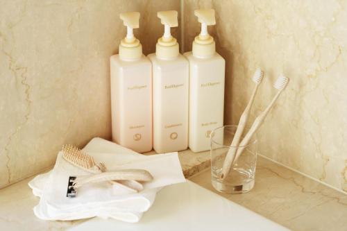 three white bottles ofodorizers sitting on a bathroom counter at Sendai Royal Park Hotel in Sendai