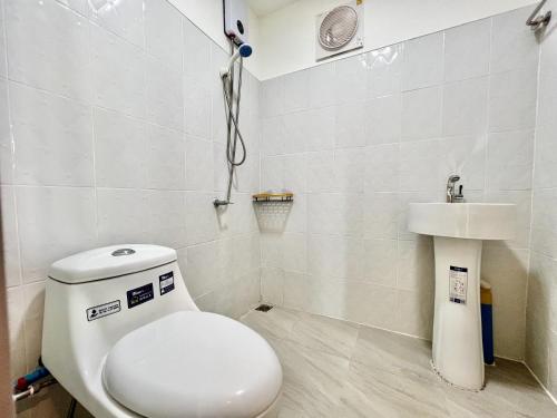 a bathroom with a toilet and a sink at Idin Klin Pha Man in Ban Nong Pla Siu