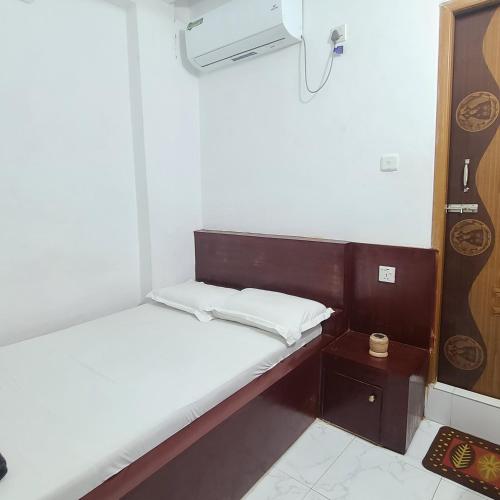 a small bed in a small room with a night stand at Hotel Muna International Residential 6th floor in Dhaka