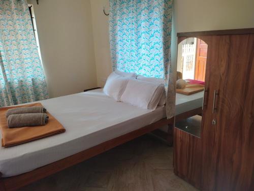 a small bedroom with a bed with a window at Bal Ganesha beach resort in Canacona