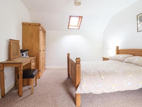 a bedroom with a bed and a desk and a bed sidx sidx sidx at Y Bwthyn in Llanbedr