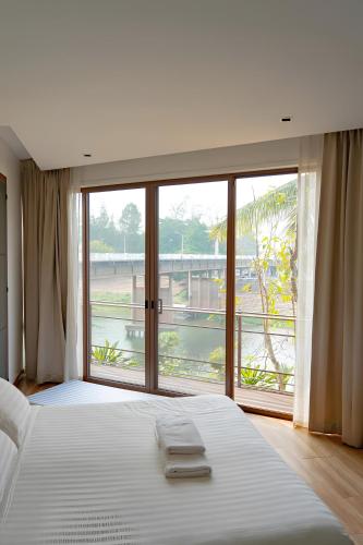 a bedroom with a large bed with a large window at Pool Villa Nam Nan in Nan